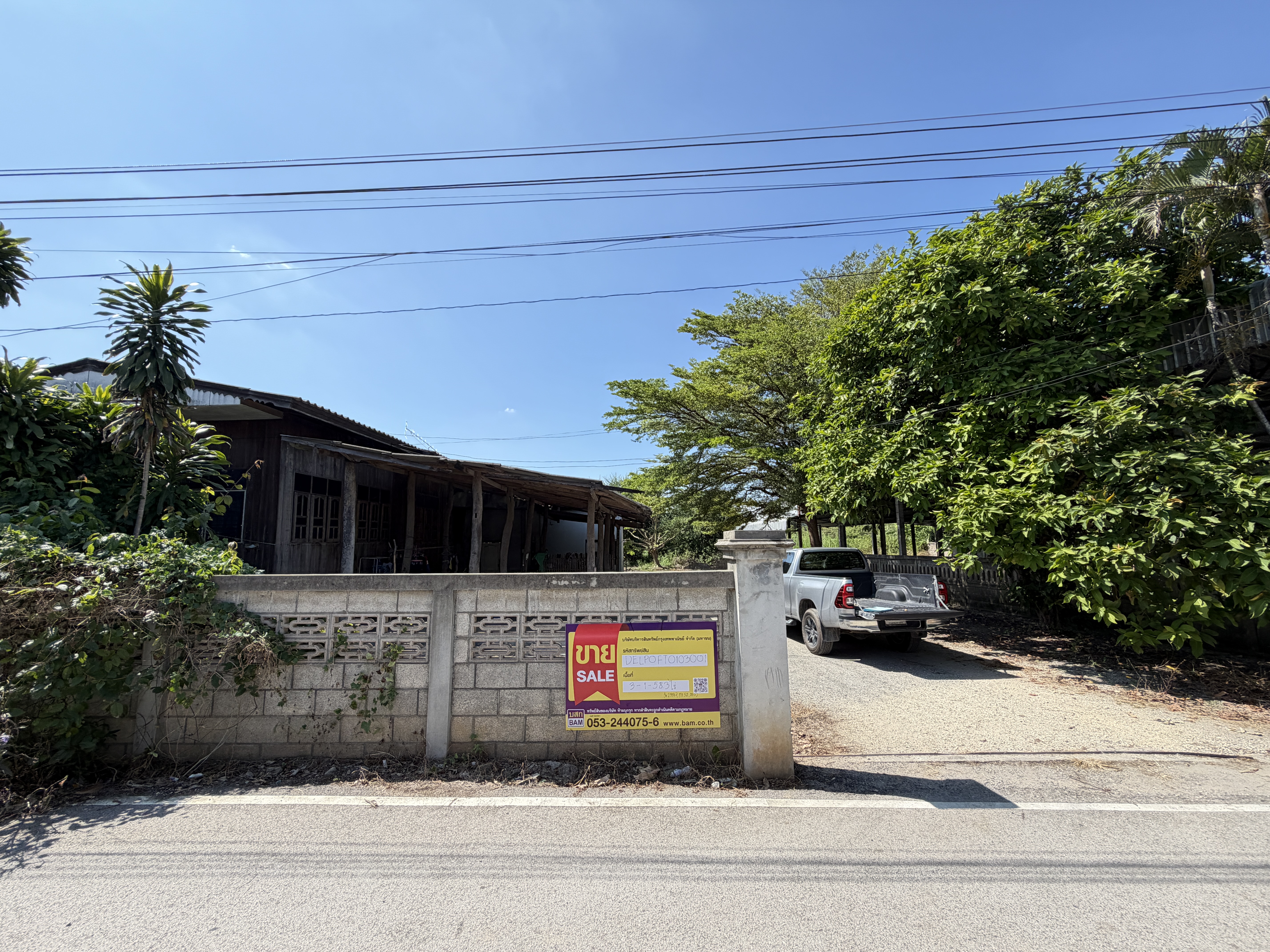 Single-story wooden house and animal shelter in Lamphun.